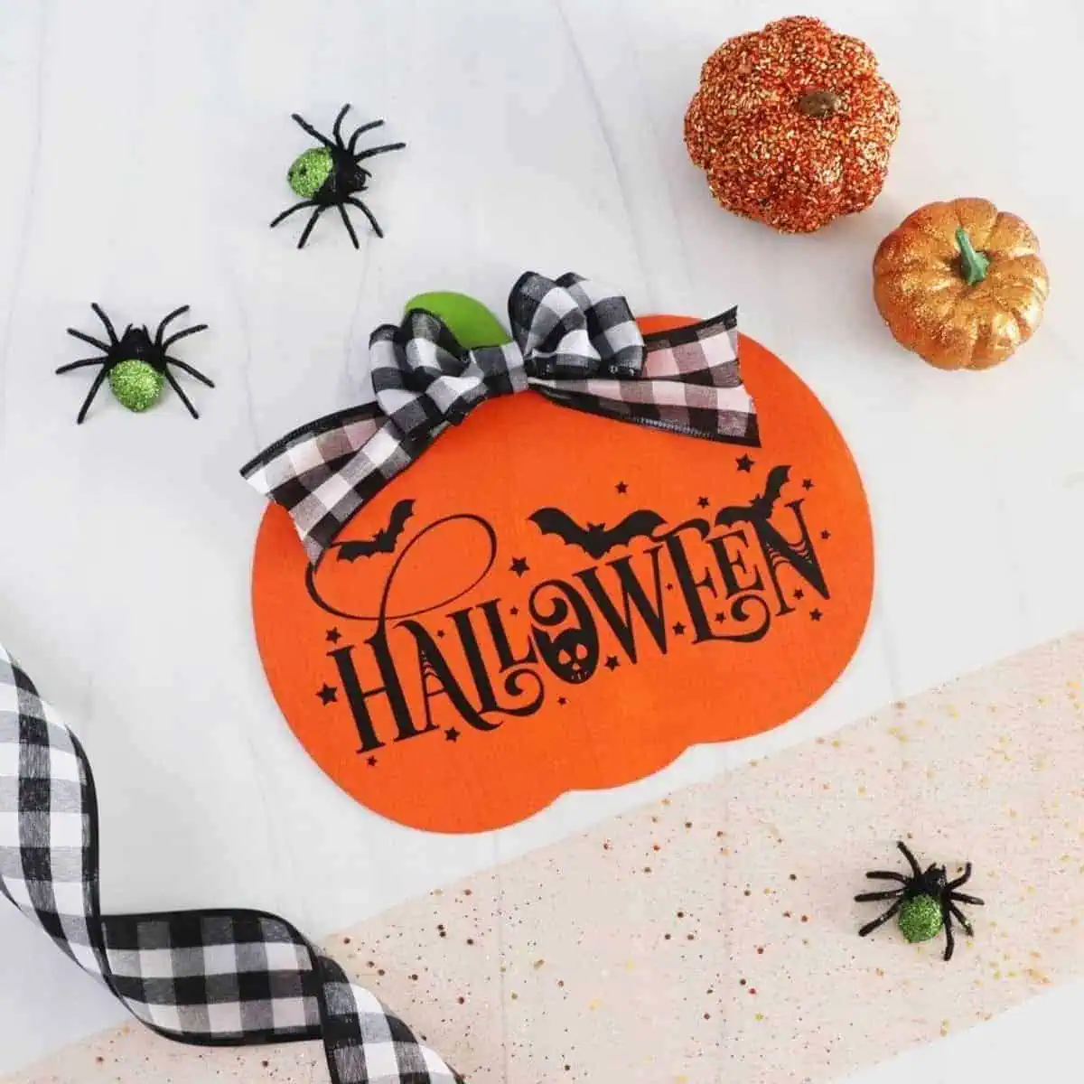 a pumpkin with a ribbon and spiders